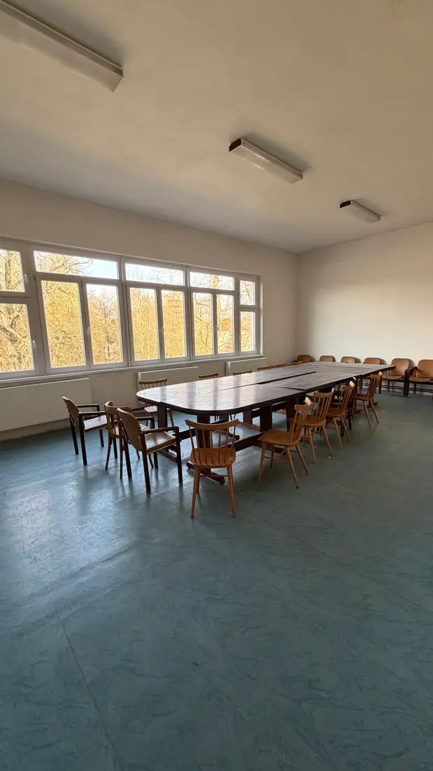 Klubovna Sokolovny s jednacím stolem
