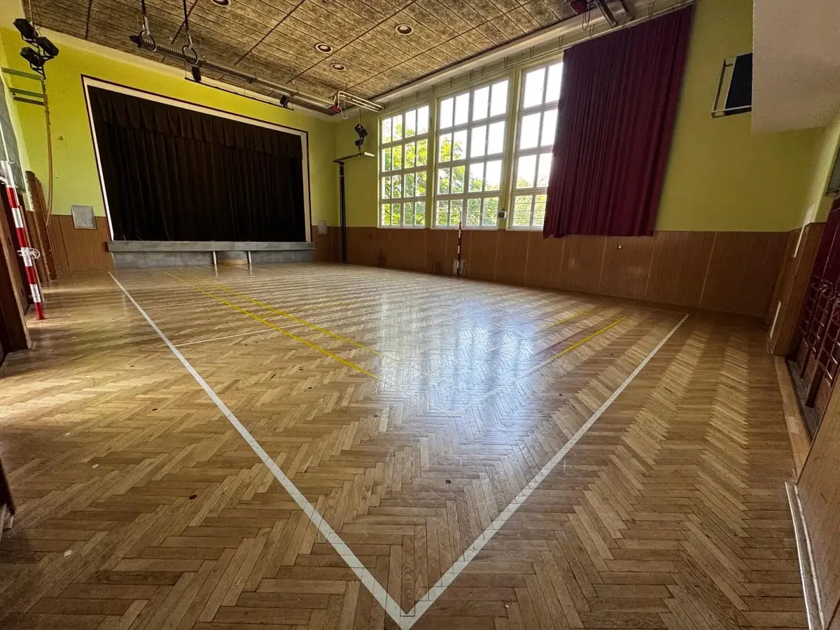 Velký cvičební sál Sokolovny s parketami a jevištěm